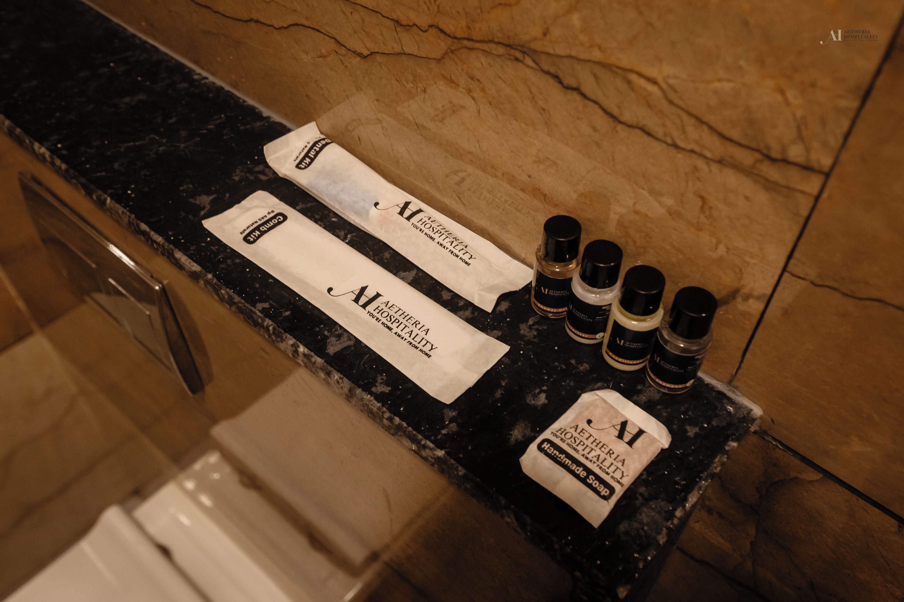 A hotel reception counter with amenities including a soap dispenser, a bottle of lotion, and a bottle of shampoo.