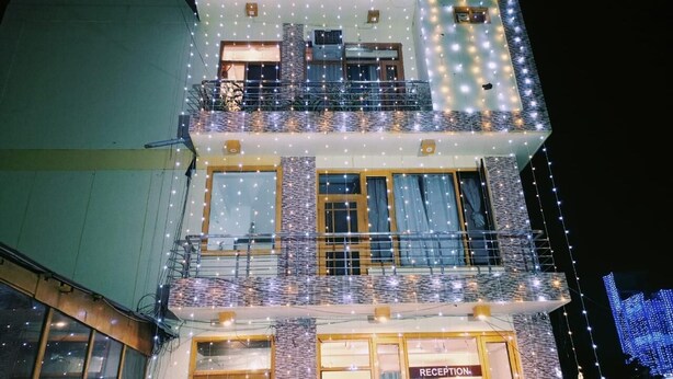 Un edificio de varios pisos con recepción en la planta baja, varios balcones y luces colgantes.