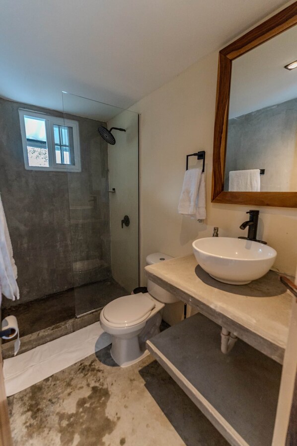 A bathroom with a white sink, a toilet, a shower, and a large mirror. - Kooteja Aurora Coronado Nature with Private Pool (Las Lajas)
