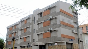 A multi-story hotel with a modern design, featuring a mix of brick and concrete facades, and several air conditioning units visible on the exterior.