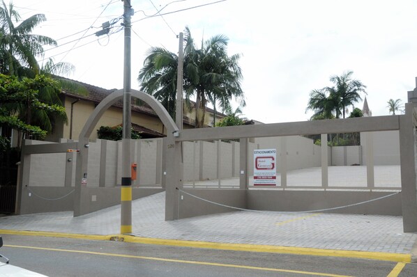 Una entrada con puerta de reja a un hotel, con un cartel que indica que es un hotel.