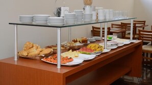 A buffet setup with various food items and plates.