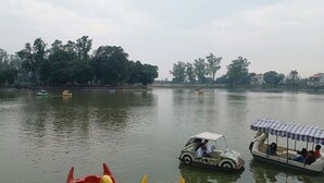 Un río tranquilo con barcos y una hilera de árboles al fondo.