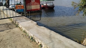 Un río tranquilo con barcos amarrados, un letrero y una reja de metal.