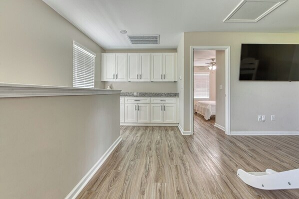 A spacious kitchen with white cabinets and a granite countertop.