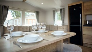 A dining area with a wooden table set for four, including wine glasses, plates, and cutlery.