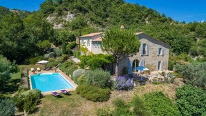 A stone house with a swimming pool, surrounded by lush greenery and hills. - Col Di Casale - A breathtaking Umbrian villa in the green heart of Italy. (Pietralunga)