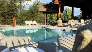 A pool area with lounge chairs and a gazebo. - Mama Bear Paw w/ private hot tub, two pools (Pigeon Forge)