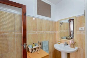 A bathroom with a wooden door, a mirror with a decorative frame, a sink with toiletries, and a towel rack. - 2 Bed Island Retreat-sleeps 4-5 Min Walk To Beach (Santa Cruz de la Palma)