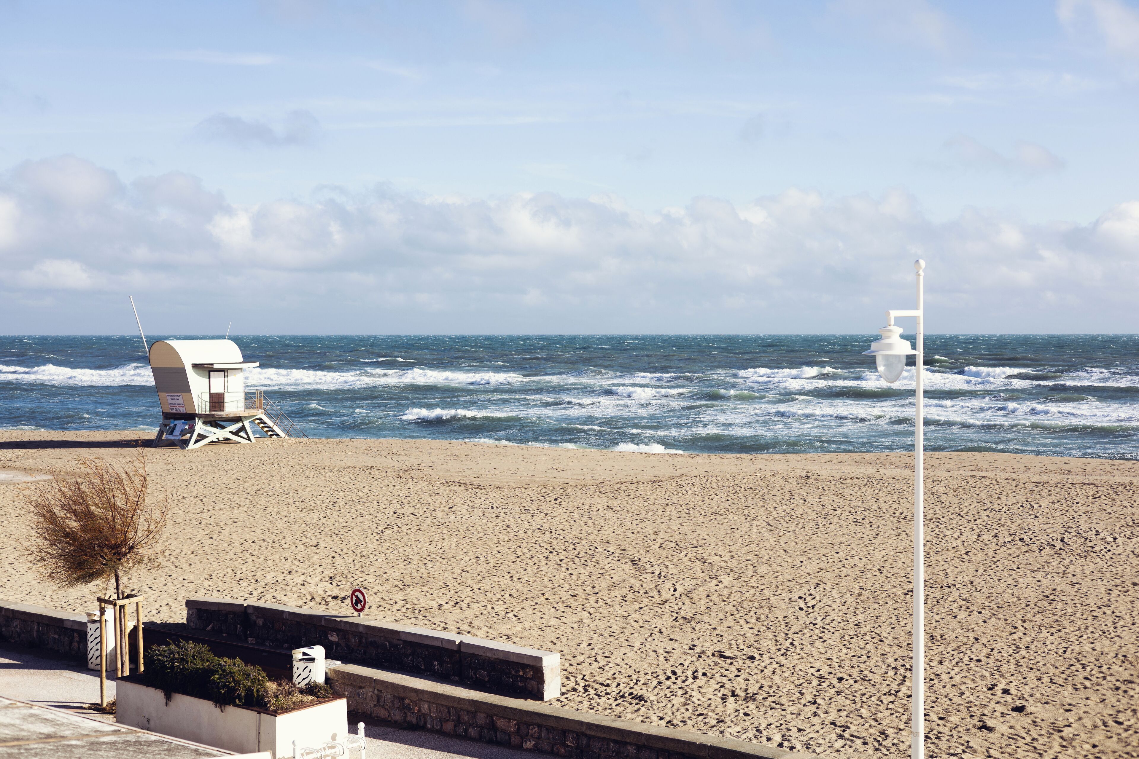 A beach with lifeguard towers and a clear view of the ocean.