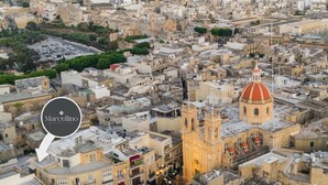 Un paisaje urbano con una iglesia destacada que presenta una cúpula y un campanario.