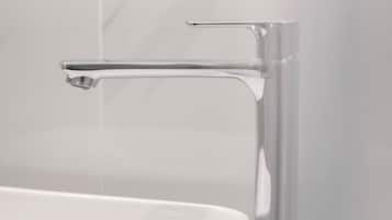 Ein modernes Badezimmer mit Waschbecken und Wasserhahn in Chrom.