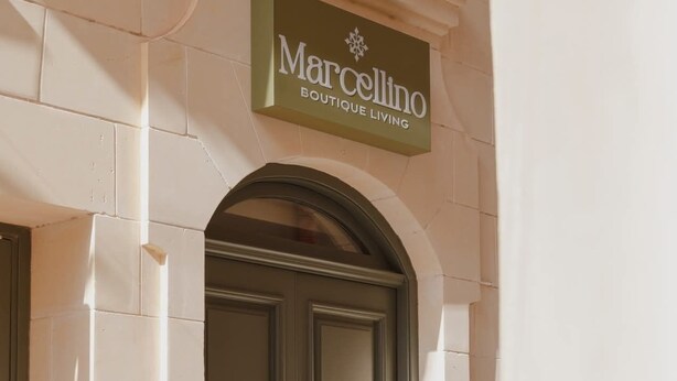 Entrada de un edificio con un cartel que dice 'Marcolino Boutique Living'.