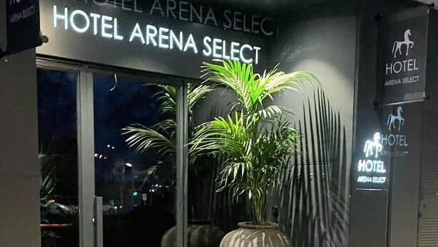 The exterior of Hotel Arena Select, featuring a modern facade, large potted plants, and a prominent signage. - Hotel Arena Select (València)