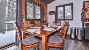 A wooden dining table with chairs, a chandelier, and a sign that says 'GATHER Together.' - Boulder Lakefront and Bike Trail Access (Boulder Junction)