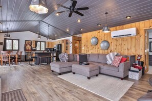 A spacious living area with a sectional sofa, dining table, and kitchen in the background. - Boulder Lakefront and Bike Trail Access (Boulder Junction)