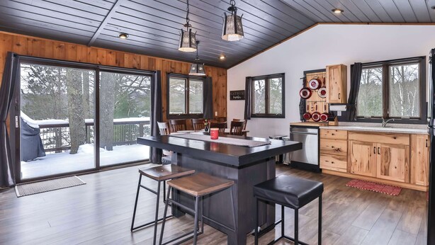 A modern kitchen with a central island, wooden cabinets, and large windows. - Boulder Lakefront and Bike Trail Access (Boulder Junction)