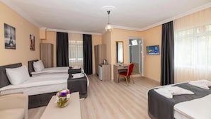 Hotelkamer met twee bedden, een bureau, een stoel, een televisie en een raam met gordijnen.