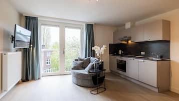 Deluxe Apartment, City View | Living area | 32-inch flat-screen TV with cable channels