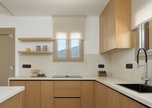 A modern kitchen with wooden cabinets, a white countertop, a built-in window, and a stainless steel sink.