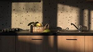 Eine Küche mit einer Arbeitsplatte, einem Spülbecken und einem gewebten Korb voller Früchte.
