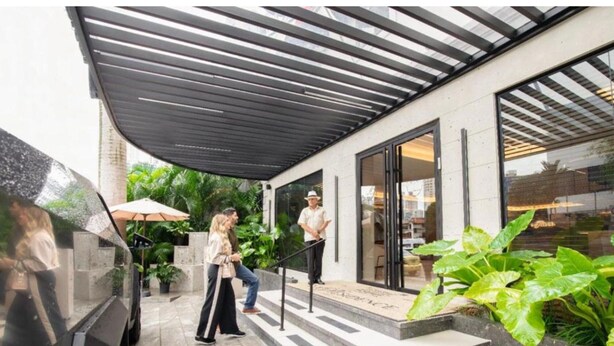 A modern building with a covered outdoor area, steps leading to a glass door, and potted plants. - THE CITY SUITE -  LA RÉSIDENCE PANAMÁ (Panamá)