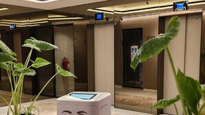 A modern lobby with a unique interactive kiosk, potted plants, and a clean, tiled floor. - THE CITY SUITE -  LA RÉSIDENCE PANAMÁ (Panamá)