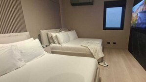A hotel room with two beds, a TV, and a window. - THE CITY SUITE -  LA RÉSIDENCE PANAMÁ (Panamá)