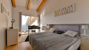 A bedroom with a large bed, a desk, and a view to the outside. - VILLA AURORE6 5 bedrooms, swimming pool, panoramic sea view (Albitreccia)