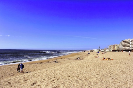 Una playa cerca, arena blanca, sombrillas, toallas de playa