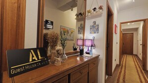 A hotel reception area with a wooden counter, a sign indicating 'Guest House de Mata', a map on the wall, and a lamp. - Guest House da Mata (A Ver-o-Mar)