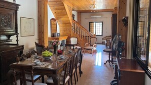 A spacious dining area with a wooden staircase leading to an upper level. - Charming Villa in Pano Platres, Cyprus - Your Home Away From Home (Platres)