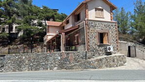 A two-story building with a stone facade and a red-tiled roof. - Charming Villa in Pano Platres, Cyprus - Your Home Away From Home (Platres)
