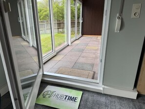 A hotel entrance with a sliding glass door leading to a patio area. - HubTime (Algermissen)