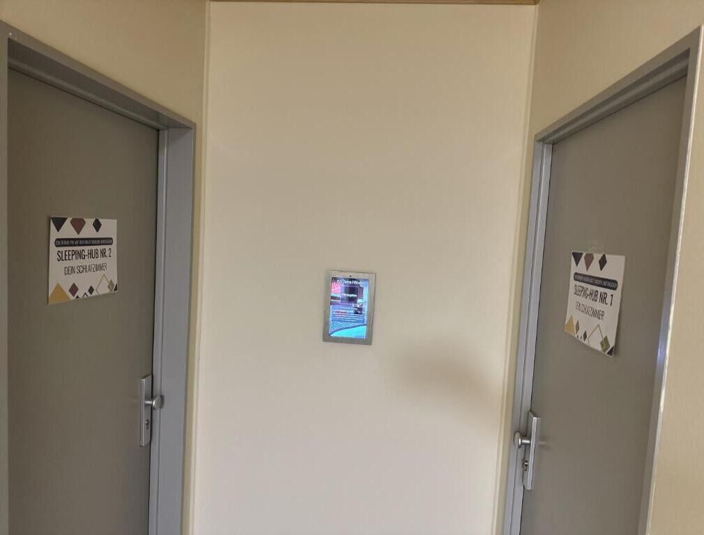 Un couloir avec deux portes, chacune étant signalée par une pancarte indiquant un espace dédié au repos.