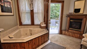 Un baño con una bañera de madera, una cesta de mimbre y una chimenea.