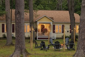 A lodge with a porch, outdoor seating, and a fire pit.