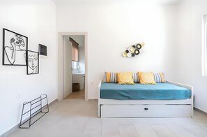 A bedroom with a bed, a bedside table, a wall-mounted TV, and abstract art on the wall.