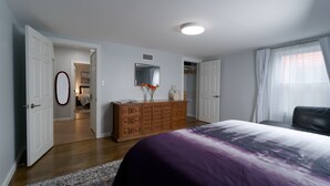 A bedroom with a bed, dresser, and walk-in closet.
