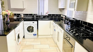 A modern kitchen with a built-in washing machine, a stove, and a sink.