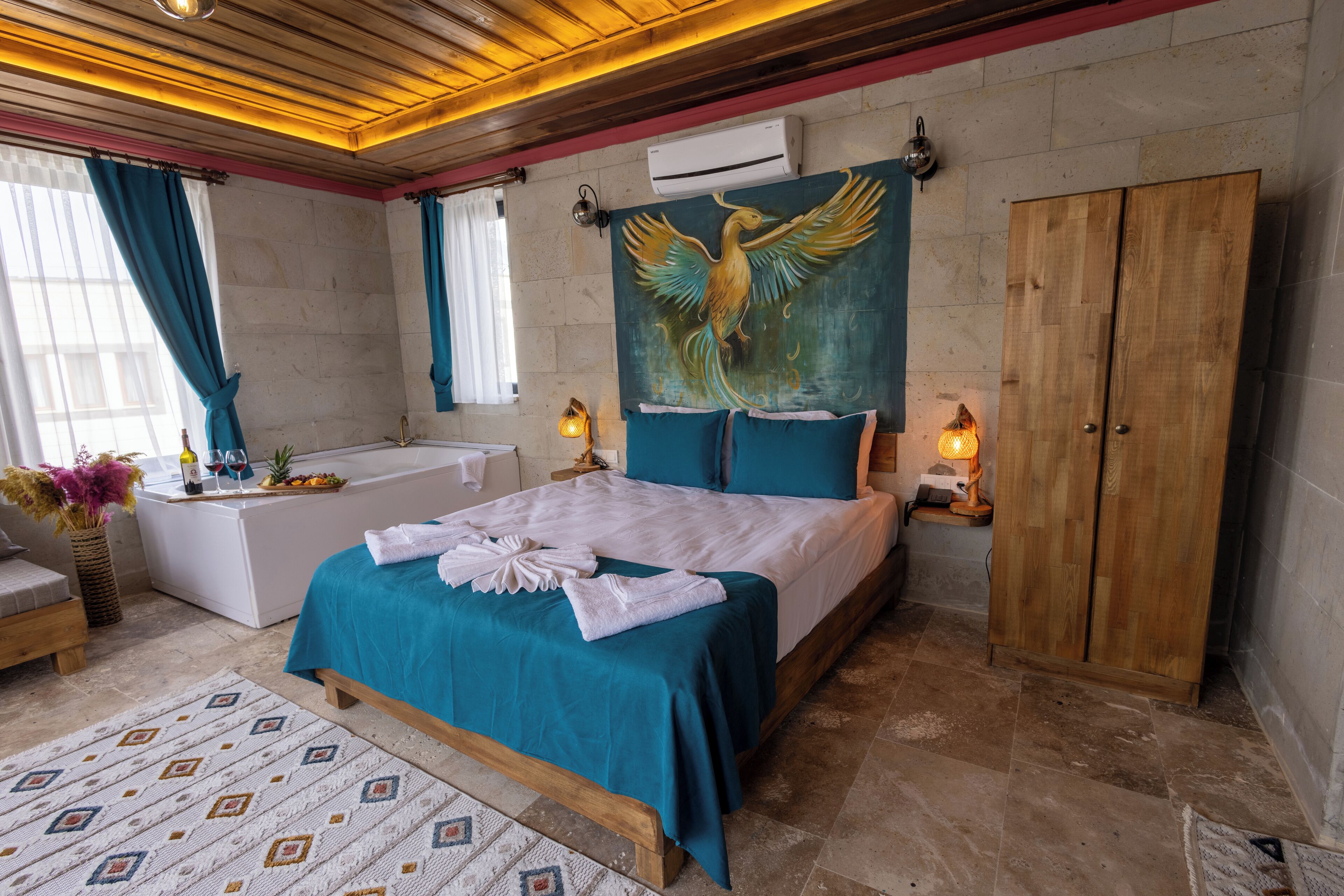 A bedroom with a bed, a wooden wardrobe, a bathtub, and a wall-mounted air conditioner.