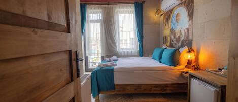 A wooden room with a bed, a small desk, and a wall-mounted air conditioner.