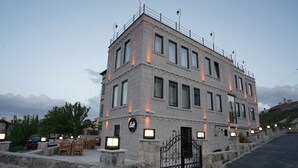 Ein mehrstöckiges Gebäude mit einer steinernen Fassade, zahlreichen Fenstern und einem Eingangstor.