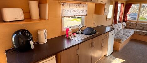 A compact kitchenette with a coffee maker, toaster, and small refrigerator.