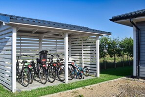 A covered bike parking area with multiple bicycles. - Holiday homes close to the beach, large playground (Sarbinowo)