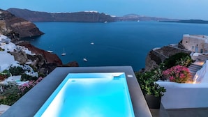 Una piscina con vistas al mar y un acantilado.