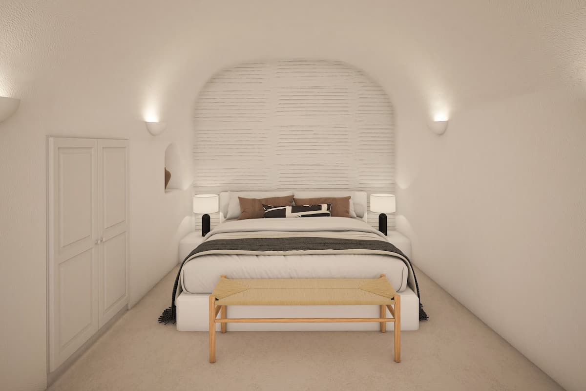 A bedroom with a bed, bedside lamps, a bench, and a door.