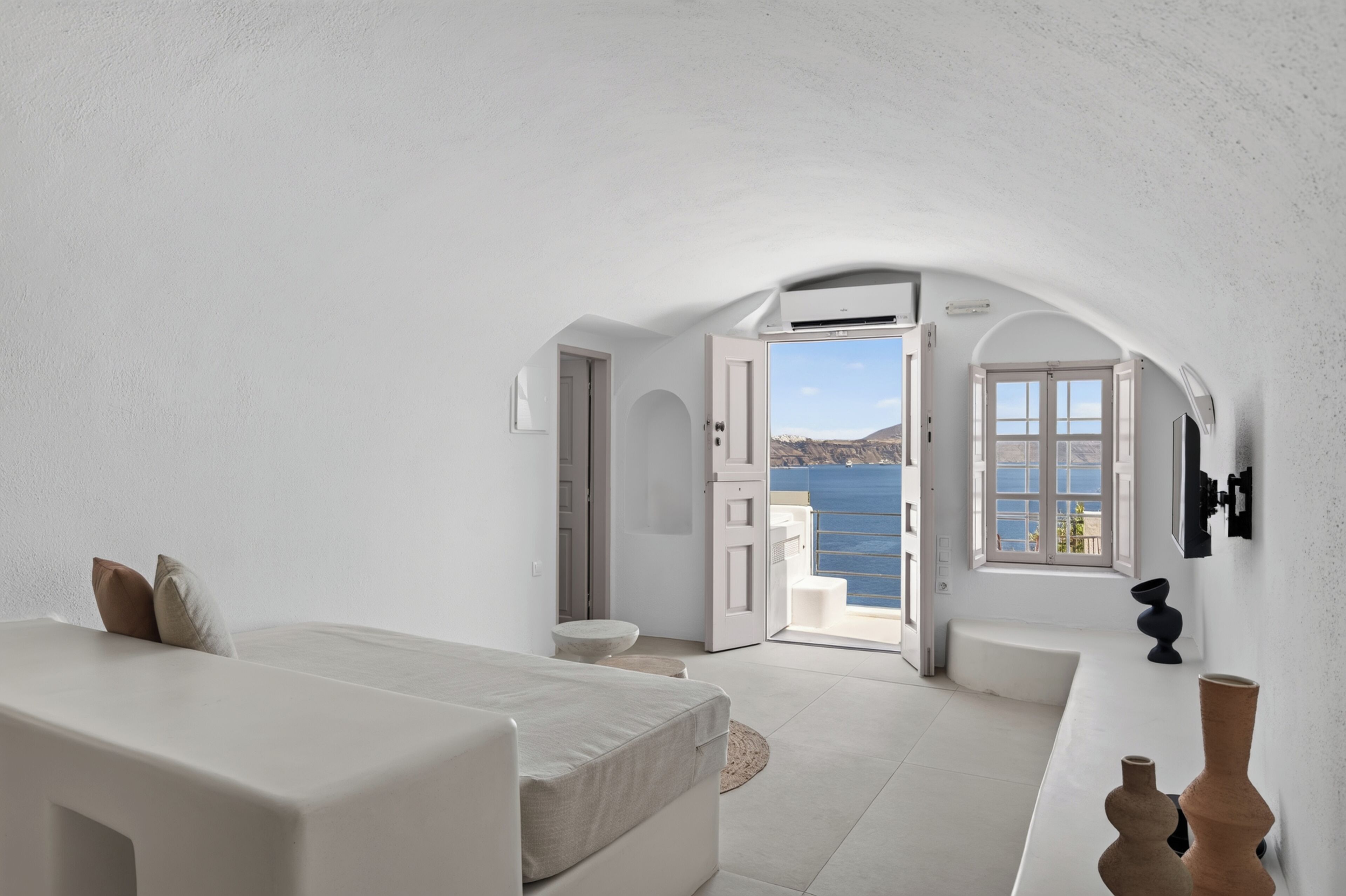 Une chambre dotée d’un lit, d’un coin salon et offrant une vue sur la mer.