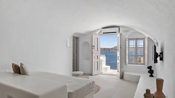 Una habitación con cama, zona de estar y vista al mar.