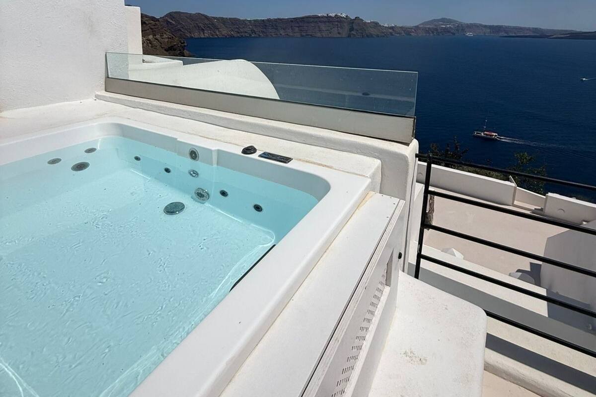 A hot tub with a clear view of the sea and distant hills.